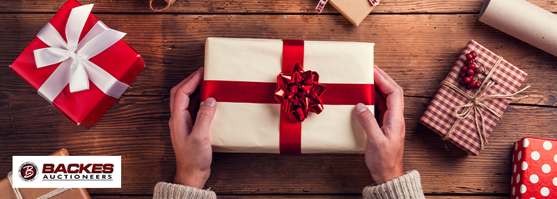 Image for Wrapped presents on a wooden table with person's hands holding the center one.
