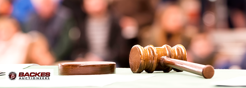 Image for Image of a gavel on table with blurred crowd in the background of an auction.